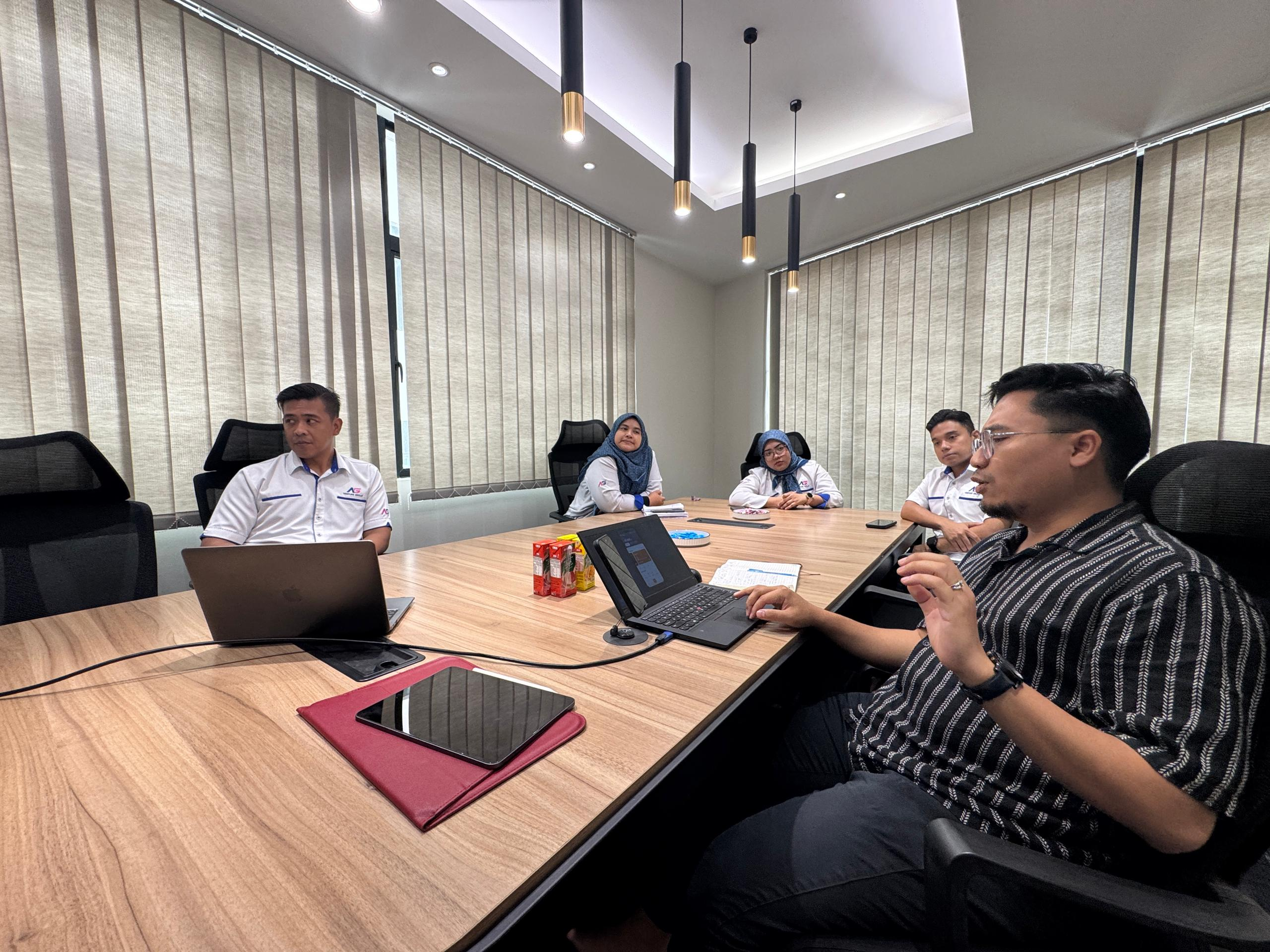 UNIVA team training around a meeting table with laptops